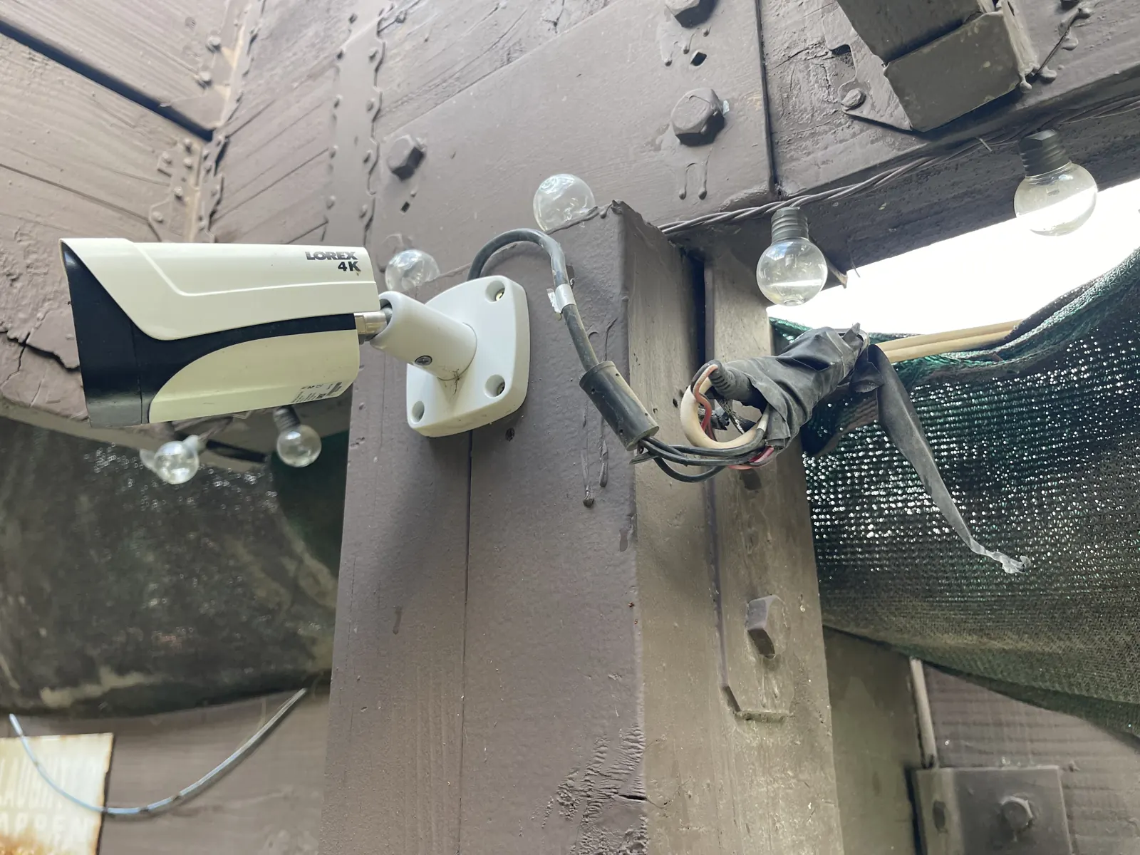 Security camera mounted on an outdoor pergola beam
