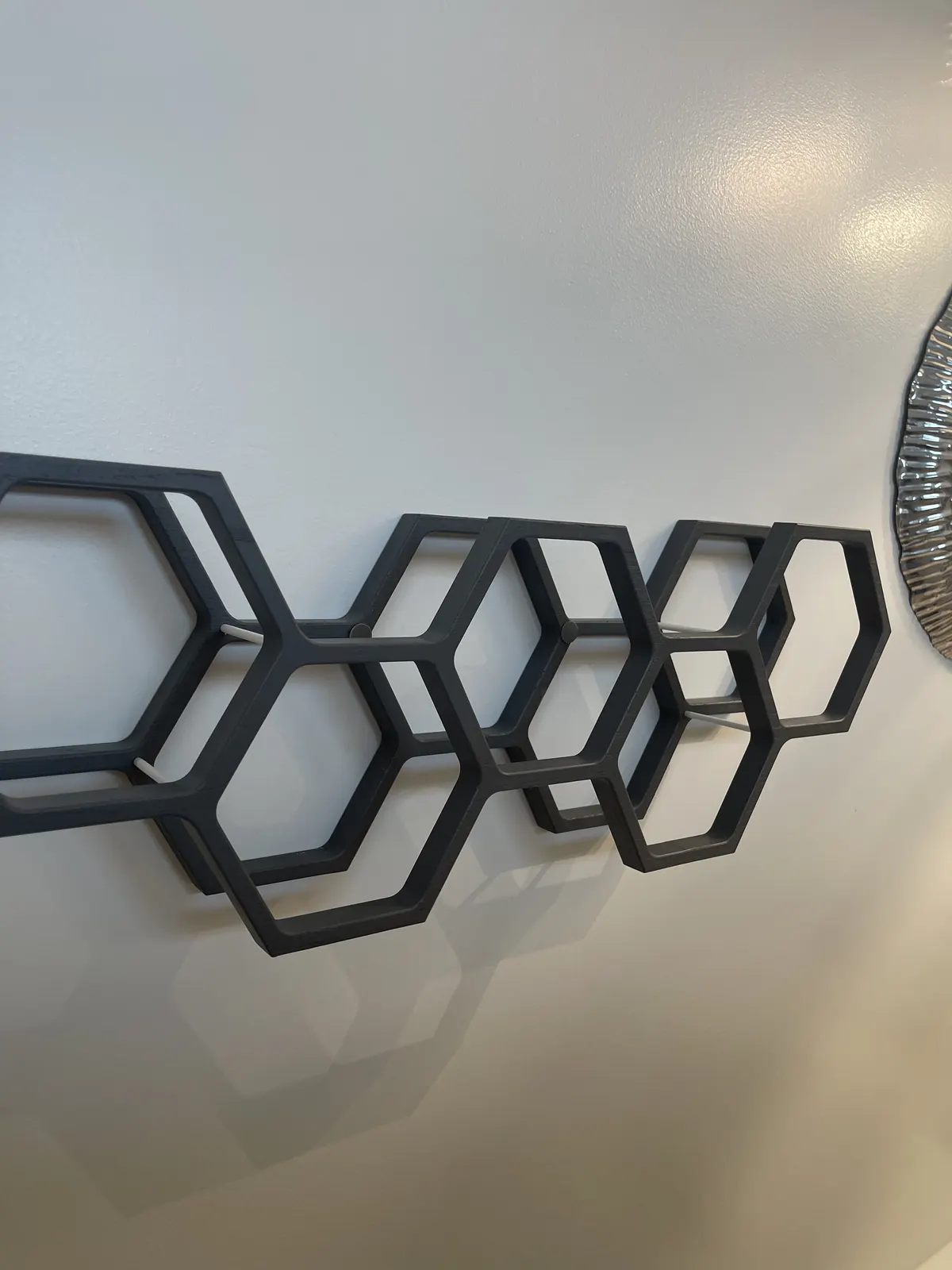 Black hexagon wall shelf hung level on a white wall