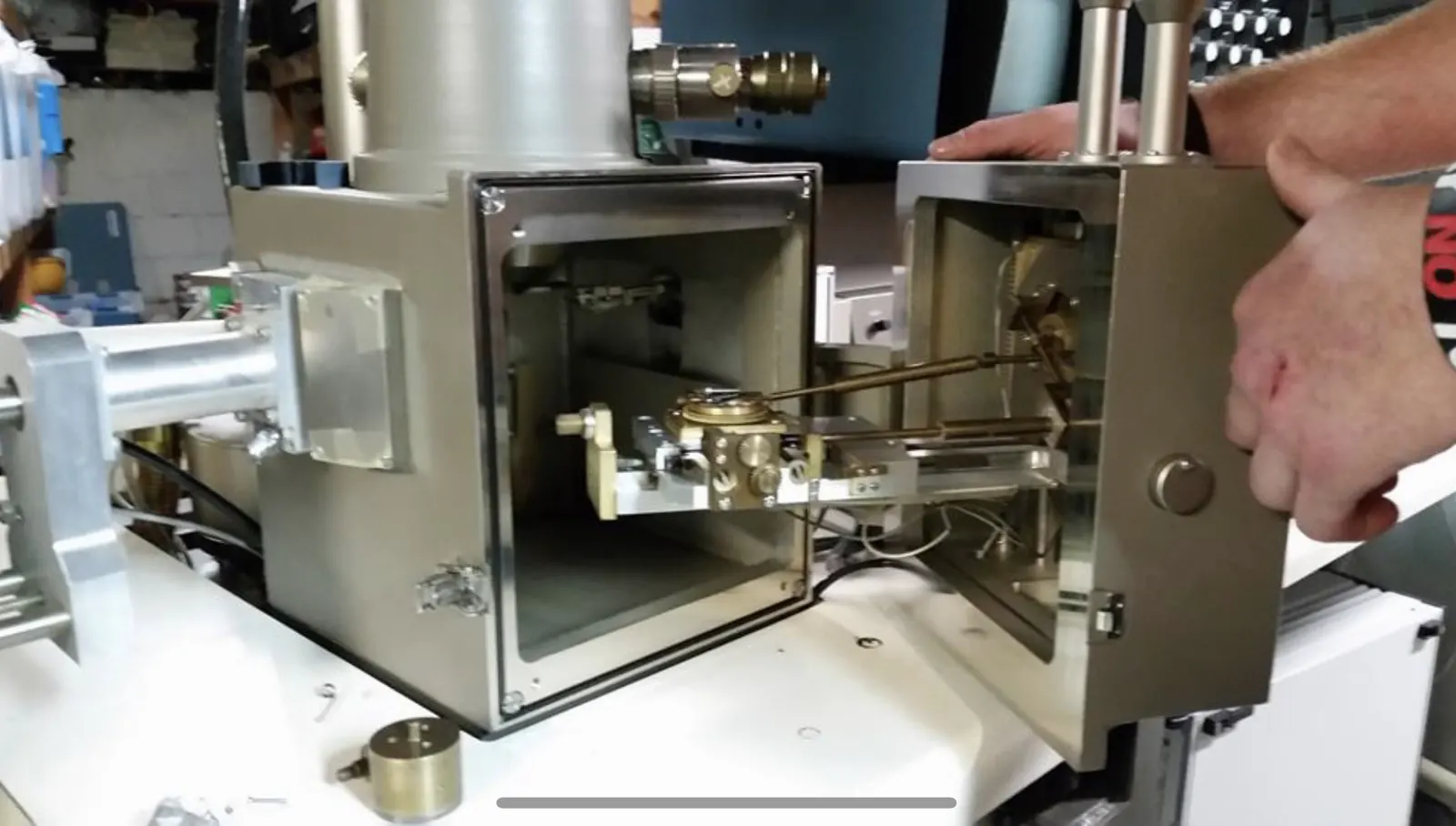 Hands at work inside an electron microscope chamber